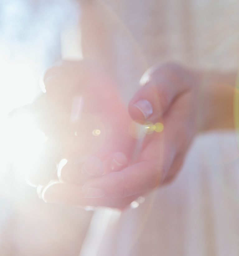Licht Helle Hände halten einen Lichtstrahl in sanfter Umgebung.